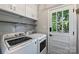 Bright laundry room with washer, dryer, cabinetry, and access to the backyard at 6624 Lancer Dr, Charlotte, NC 28226