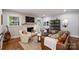 Cozy living room featuring a brick fireplace, wood-paneled walls, and stylish decor at 6624 Lancer Dr, Charlotte, NC 28226