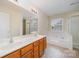 Bathroom featuring a soaking tub, glass shower and double sink vanity at 6948 Church Wood Ln, Huntersville, NC 28078