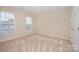 Bright bedroom features two windows, neutral walls, and carpet flooring at 6948 Church Wood Ln, Huntersville, NC 28078