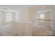 Upstairs hallway with carpet, natural light, and white railing at 6948 Church Wood Ln, Huntersville, NC 28078