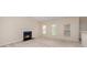 Cozy living room with a fireplace, neutral carpet, and three large windows at 6948 Church Wood Ln, Huntersville, NC 28078