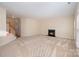 Spacious living room with a cozy fireplace, neutral carpet, and ample natural light from large windows at 6948 Church Wood Ln, Huntersville, NC 28078