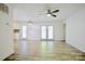 Bright living room with sleek hardwood floors and a ceiling fan, with glass doors to outside at 7416 Quail Ridge Dr, Charlotte, NC 28226