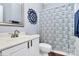 Clean bathroom with a white vanity, toilet, decorative mirror, and blue patterned shower curtain at 7544 Rolling Meadows Ln, Huntersville, NC 28078