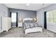 A well-lit bedroom features plush carpeting, neutral paint and two large windows at 7544 Rolling Meadows Ln, Huntersville, NC 28078