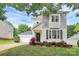 Charming two-story home with manicured lawn, lush landscaping, and a detached garage at 7544 Rolling Meadows Ln, Huntersville, NC 28078