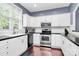 The kitchen is well-lit with white cabinets, stainless steel appliances and dark countertops at 7544 Rolling Meadows Ln, Huntersville, NC 28078