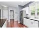 Kitchen featuring stainless steel appliances, white cabinets, black countertops, and hardwood flooring at 7544 Rolling Meadows Ln, Huntersville, NC 28078