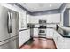 A cozy kitchen features stainless steel appliances, white cabinets and black countertops at 7544 Rolling Meadows Ln, Huntersville, NC 28078