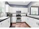 Open-concept kitchen features modern stainless steel appliances and updated white cabinetry at 7544 Rolling Meadows Ln, Huntersville, NC 28078