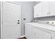 Functional laundry room with white cabinets, washer, dryer, and access door at 7544 Rolling Meadows Ln, Huntersville, NC 28078