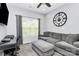 Cozy living room featuring a gray couch, carpet, fan, and a window providing natural light at 7544 Rolling Meadows Ln, Huntersville, NC 28078