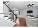 Spacious living room featuring hardwood floors, a ceiling fan, stairs and open views to the kitchen at 7544 Rolling Meadows Ln, Huntersville, NC 28078