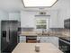 Modern kitchen with stainless steel appliances, ample counter space, and a well-lit dining nook by the window at 772 Austin Rd, New London, NC 28127