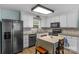 Updated kitchen with stainless steel refrigerator, white cabinets, and a cozy eat-in area with natural light at 772 Austin Rd, New London, NC 28127