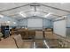 Open-concept recreational area including a projector screen and seating, with a roll up door at 772 Austin Rd, New London, NC 28127