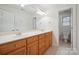 Bright bathroom features a double sink vanity with wooden cabinets and a separate toilet room at 8216 Malibu Pointe Ln, Denver, NC 28037