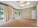 Large main bedroom with neutral carpeting, tray ceiling and access to a private deck with lake views at 8216 Malibu Pointe Ln, Denver, NC 28037