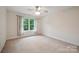 Bright bedroom with a ceiling fan, large window, and light walls and carpet at 8216 Malibu Pointe Ln, Denver, NC 28037