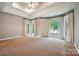 Spacious main bedroom features tray ceilings, ceiling fan, and natural light from multiple windows at 8216 Malibu Pointe Ln, Denver, NC 28037