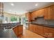 Well-lit kitchen featuring wood cabinetry, stainless steel appliances, and a breakfast bar area at 8216 Malibu Pointe Ln, Denver, NC 28037