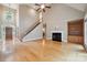 Spacious living room with hardwood floors, a fireplace, and a staircase leading to the upper level at 8216 Malibu Pointe Ln, Denver, NC 28037