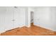 Bright bedroom featuring gleaming hardwood floors, white walls, and closet at 862 Mcalway Rd, Charlotte, NC 28211