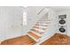 Bright foyer featuring hardwood floors, staircase, and a convenient laundry area at 862 Mcalway Rd, Charlotte, NC 28211