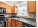 Bright kitchen featuring stainless steel sink, wooden cabinets, and window at 862 Mcalway Rd, Charlotte, NC 28211