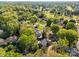 An aerial view showing the house nestled among mature trees in a beautiful neighborhood with a golf course nearby at 961 Confederate Ave, Salisbury, NC 28144