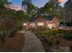 Charming brick home featuring a manicured front yard with lush landscaping and a winding driveway at 961 Confederate Ave, Salisbury, NC 28144
