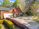 Brick home featuring an attached garage, and patio seating, surrounded by lush, colorful landscaping at 961 Confederate Ave, Salisbury, NC 28144