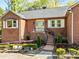 Charming brick home with a welcoming front porch, complemented by manicured landscaping and a cozy bench at 961 Confederate Ave, Salisbury, NC 28144