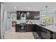 A renovated kitchen features dark cabinets, granite countertops, stainless appliances, and hardwood floors at 961 Confederate Ave, Salisbury, NC 28144