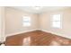 Bedroom with hardwood floors, baseboard trim and two windows for natural light at 104 Willetta Dr, Charlotte, NC 28217