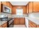 Bright kitchen showcasing wood cabinets, stainless steel appliances, and tile backsplash at 104 Willetta Dr, Charlotte, NC 28217