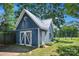 Detailed view of blue barn featuring 'Z' doors, white trim, and silver metal roof at 108 Stockton St, Shelby, NC 28150