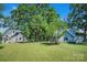 Sprawling lawn view featuring two detached homes with mature shade trees and blue skies at 108 Stockton St, Shelby, NC 28150