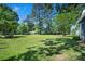 Lush green yard with mature shade trees casting shadows across the landscape at 108 Stockton St, Shelby, NC 28150