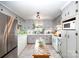 Efficient kitchen with stainless steel refrigerator, white cabinets, tiled floors, and natural lighting at 1115 Grovewood Dr, Charlotte, NC 28208