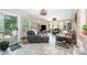 Bright sunroom with tiled floors, leather furniture, multiple windows, and pleasant outdoor views at 1115 Grovewood Dr, Charlotte, NC 28208