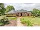 Charming brick home with manicured lawn, arched windows, and a welcoming walkway to the front door at 1337 Braeburn Nw Rd, Concord, NC 28027