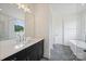 Bright bathroom featuring a vanity with modern fixtures and a glass-enclosed shower and standalone tub in the background at 13605 Tranquil Day Dr, Matthews, NC 28105