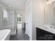 Modern bathroom featuring dual vanity sinks, a glass-enclosed shower, and a freestanding tub at 13605 Tranquil Day Dr, Matthews, NC 28105