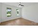 Bright bedroom features hardwood floors, two windows, and ceiling fan at 13605 Tranquil Day Dr, Matthews, NC 28105