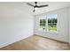 Bright bedroom with light hardwood floors, a ceiling fan, and a large window at 13605 Tranquil Day Dr, Matthews, NC 28105