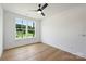 Bright bedroom with light hardwood floors, a ceiling fan, and a large window at 13605 Tranquil Day Dr, Matthews, NC 28105