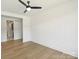 Bright bedroom with light hardwood floors, a ceiling fan, and a connecting door at 13605 Tranquil Day Dr, Matthews, NC 28105