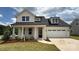 Charming two-story home with a two car garage, a manicured lawn, and beautiful landscaping at 13605 Tranquil Day Dr, Matthews, NC 28105